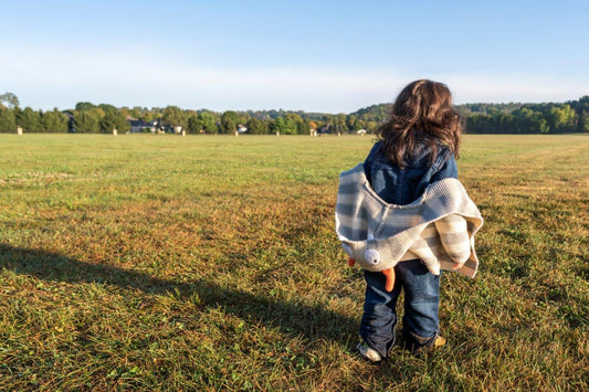 child walking through a big field free and relaxed