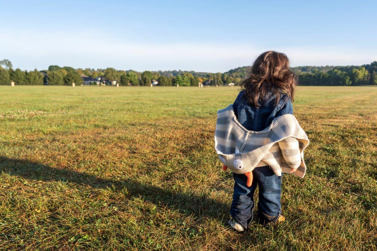 child walking through a big field free and relaxed